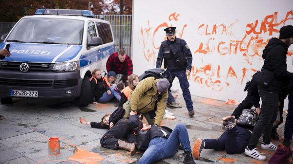Сотрудники полиции отгоняют экоактивистов движения Последнее поколение от здания канцелярии в Берлине, Германия