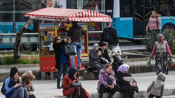 Люди отдыхают на одной из улиц в районе Кадыкей города Стамбул