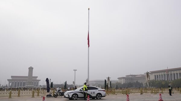 Полицейские рядом с приспущенным флагом в связи с трауром по бывшему премьер-министру Ли Кэцяну на площади Тяньаньмэнь в Китае. 2 ноября 2023