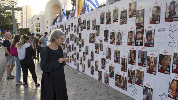 Фотографии израильтян, пропавших без вести и находящихся в заложниках в секторе Газа, на стенде в Тель-Авиве