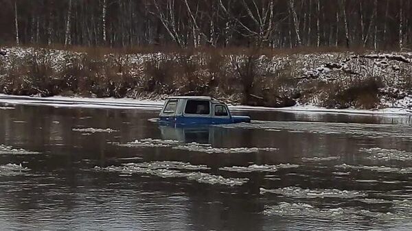 Эвакуация женщины из автомобиля, застрявшего на реке Урюп в Шарыповском райо­не Красноярского края