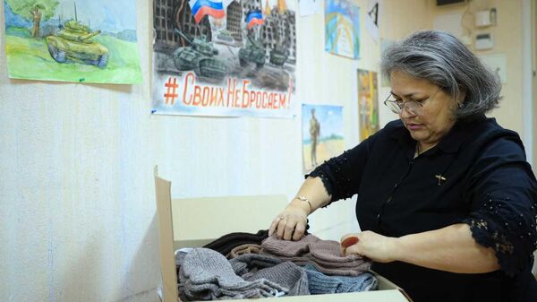 Вдова Героя России из Петербурга упаковывает шерстяные носки, которые она вяжет для бойцов СВО