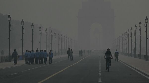 Люди гуляют в условиях критически загрязненного воздуха около монумента Ворота Индии в Нью-Дели. 3 ноября 2023
