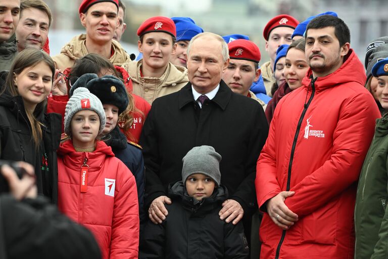 Президент РФ Владимир Путин фотографируется с волонтерами, участниками поисковых движений и детьми погибших героев специальной военной операции (СВО) после церемонии возложения цветов к памятнику Кузьме Минину и Дмитрию Пожарскому на Красной площади в День народного единства