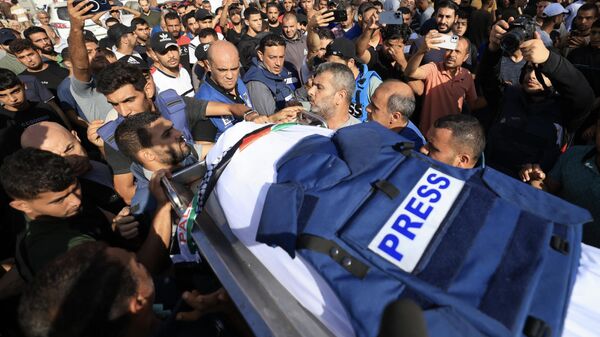 Журналисты, родственники и друзья на похоронах палестинского тележурналиста Мохаммада Абу Хаттаба, погибшего при израильском авиаударе по сектору Газа