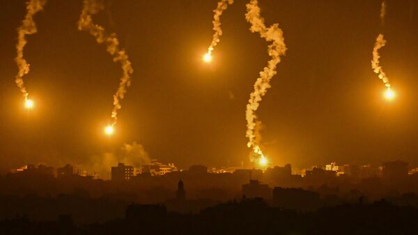 Сигнальные ракеты, сброшенные Армией обороны Израиля, освещают территорию сектора Газа