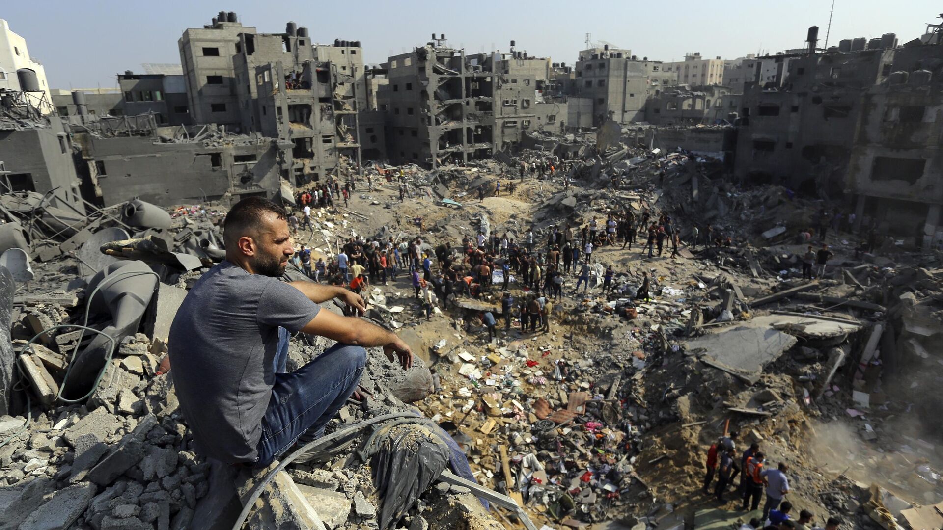Мужчина сидит на обломках разрушенных после израильского авиаудара зданий в секторе Газа - РИА Новости, 1920, 22.11.2023