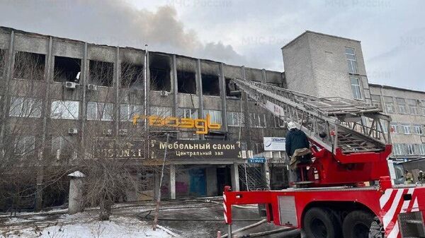 Сотрудники МЧС РФ во время ликвидации возгорания торгового центра Гвоздь в Улан-Удэ