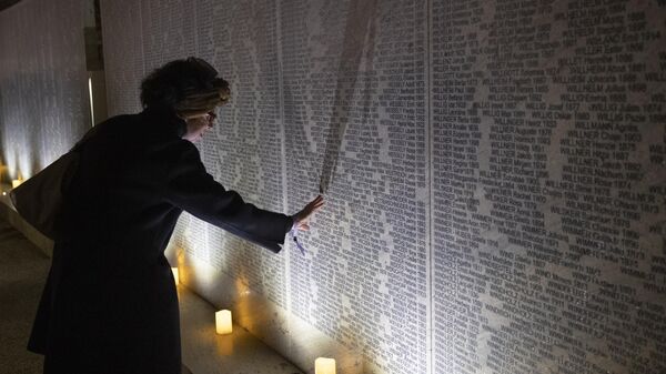 Женщина у мемориала Стена имен Шоа в годовщину Хрустальной ночи в Вене. Архивное фото
