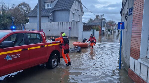 Сотрудники Пожарной части на одной из затопленных улиц в департаменте Па-де-Кале во Франции 