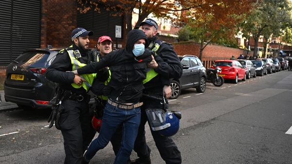 Полицейские задерживают мужчину недалеко от пропалестинской акции в центре Лондона. 11 ноября 2023