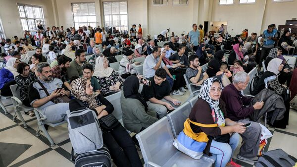 Люди сидят в зоне ожидания на пограничном переходе Рафах на юге сектора Газа