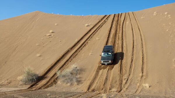 Машина едет по бездорожью в пустыне в Маскате 