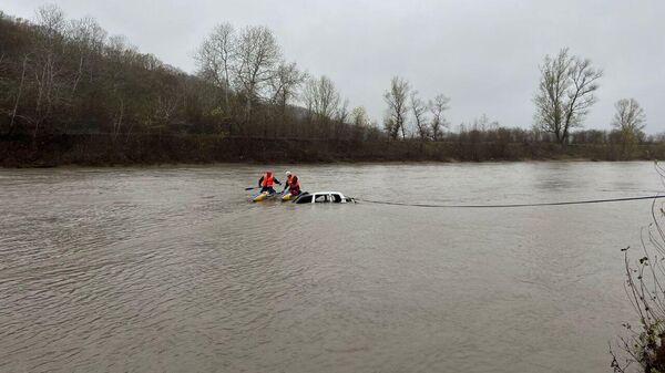 Спасатели с помощью троса вытаскивают затонувший автомобиль из реки Белая в Адыгее
