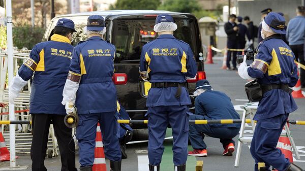 Полицейские возле посольства Израиля в Токио, где автомобиль врезался в заграждение