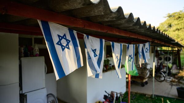 Израильские флаги на крыльце дома в кибуце Дан, недалеко от ливанской границы