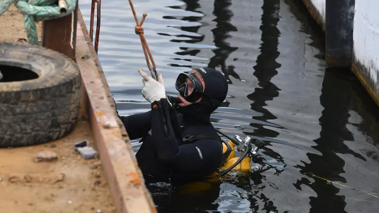 Водолаз во время работы по очистке от мусора дна причалов Северного речного вокзала Водолаз во время работы по очистке от мусора дна причалов Северного речного вокзала