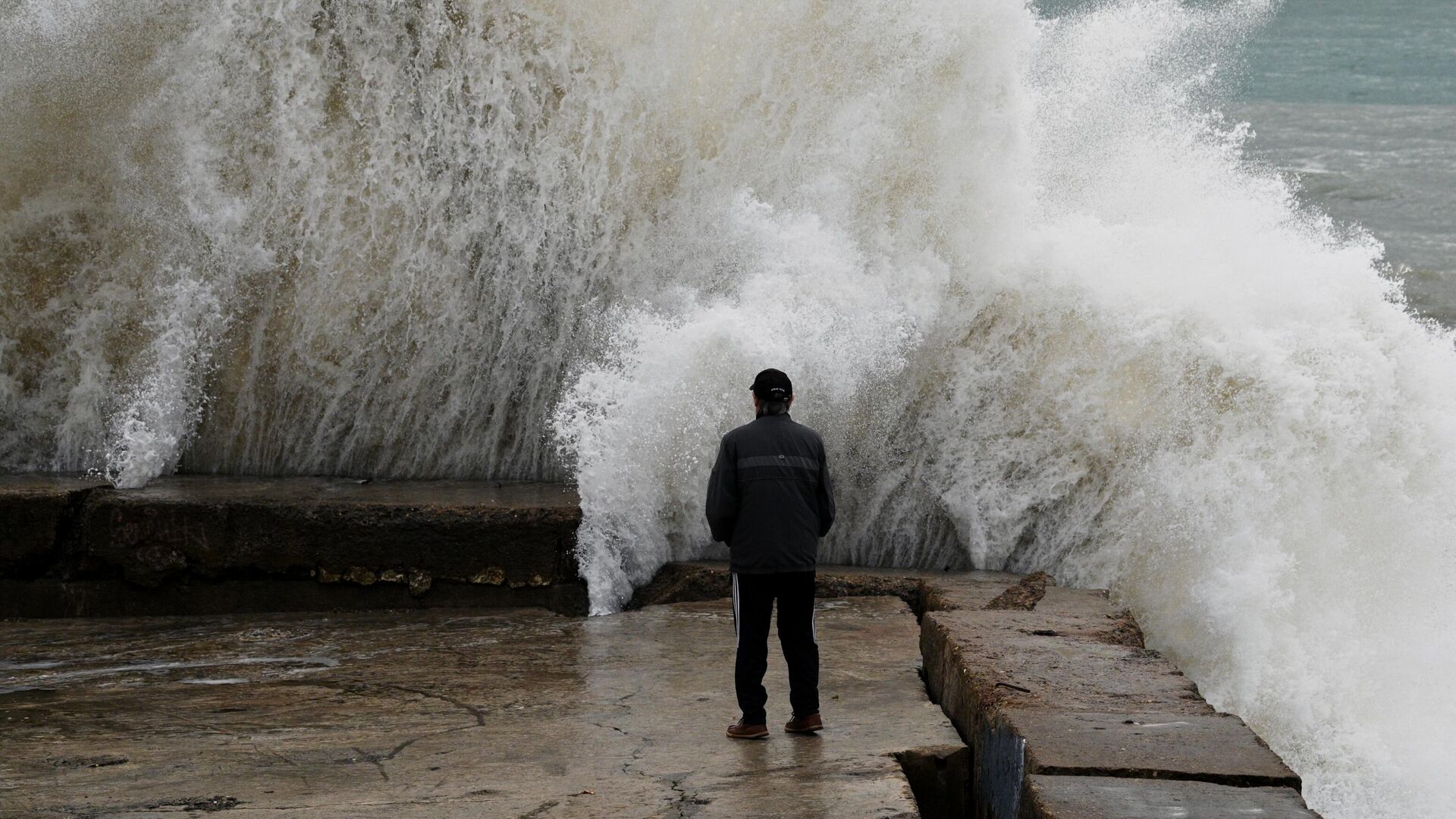 Мужчина на берегу Черного моря в Сочи в штормовую погоду - РИА Новости, 1920, 21.11.2023