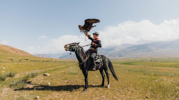 Охотник демонстрирует умение обращаться с беркутом, Кыргызстан