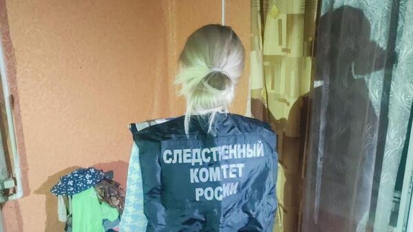 Сотрудница СК России проводит осмотр места происшествия в Псковской области, где были обнаружены тела детей