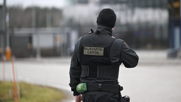 Финский пограничник стоит на пограничном пункте Нуйямаа на российско-финской границе