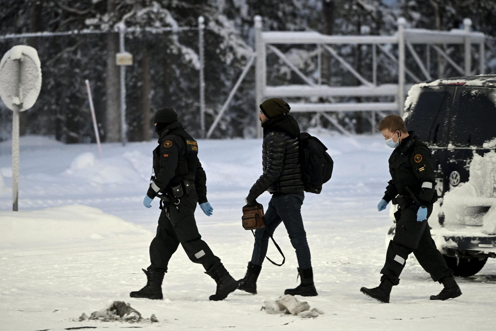 Офицеры финской пограничной службы сопровождают мигранта на КПП Райа-Йоосеппи в северной Финляндии - РИА Новости, 1920, 04.12.2023