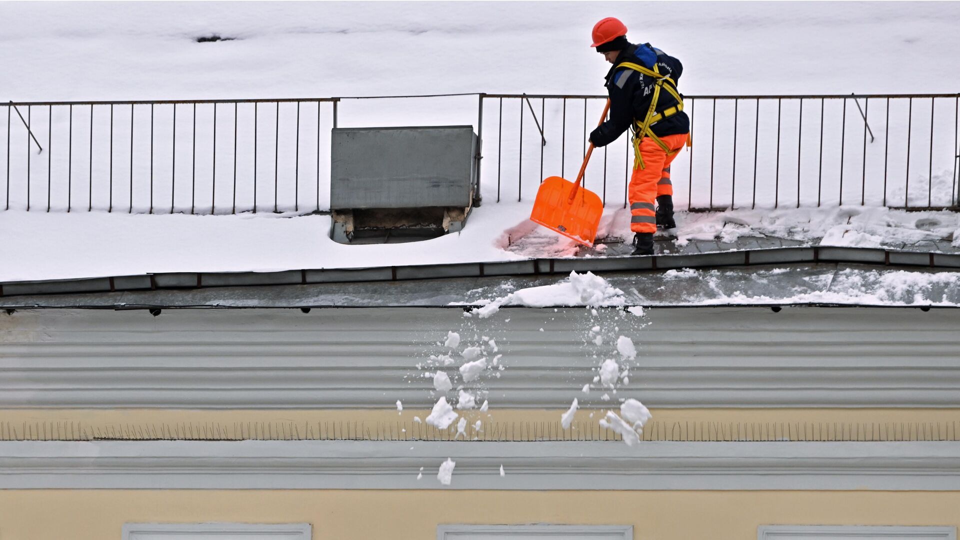 Работник коммунальной службы очищает крышу дома после снегопада в Москве - РИА Новости, 1920, 04.12.2023