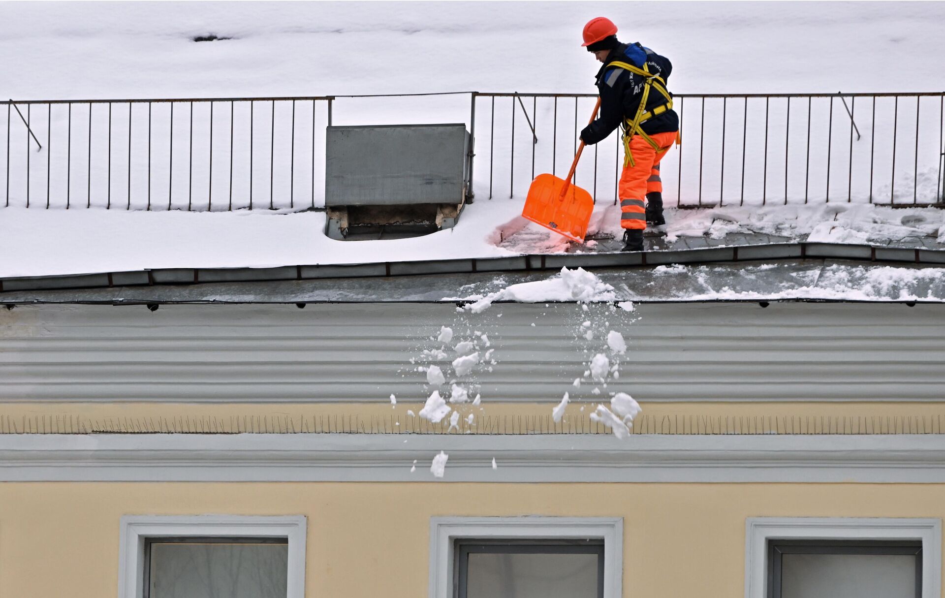 Работник коммунальной службы очищает крышу дома после снегопада в Москве - РИА Новости, 1920, 27.11.2023