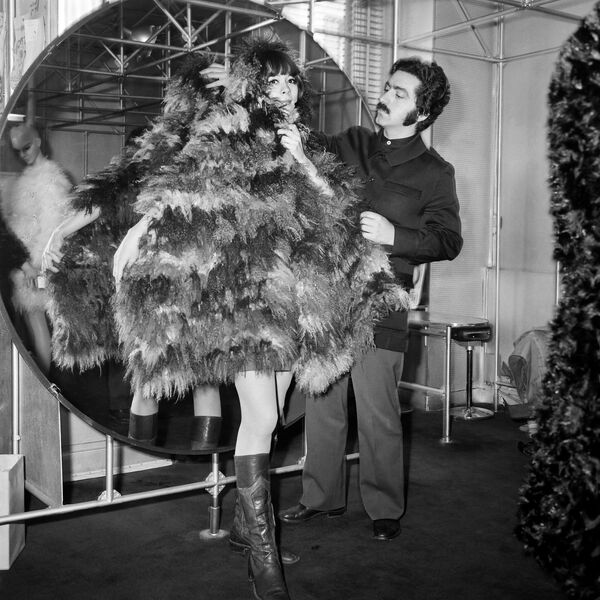 Французский модельер Пако Рабан одевает манекенщицу в своем магазине в Париже в 1968 году