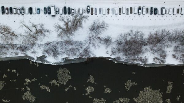 Припаркованные машины на берегу реки Иня после снегопада в Новосибирске