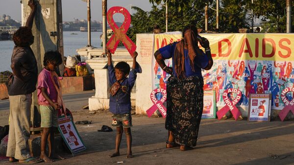 Люди на берегу реки Хугли в преддверии Всемирного дня борьбы со СПИДом в Калькутте