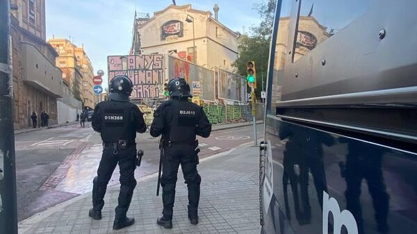Полицейские по время операции по выселению людей, незаконно проживающих в домах в Каталонии