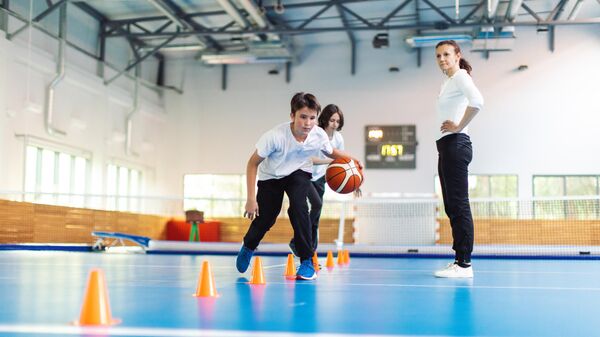 Ученики занимаются физкультурой в спортивном зале школы