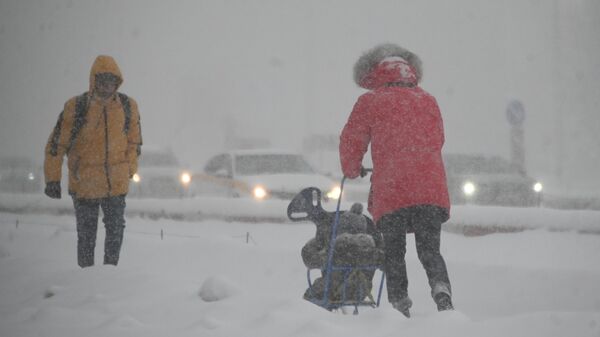 Люди на Ленинском проспекте во время сильного снегопада в Москве