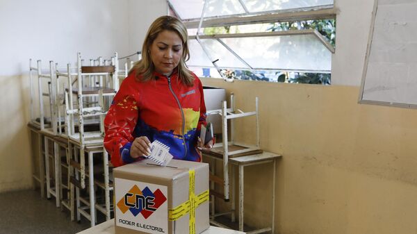 Женщина голосует на референдуме в защиту прав на территорию Эссекибо в Каракасе