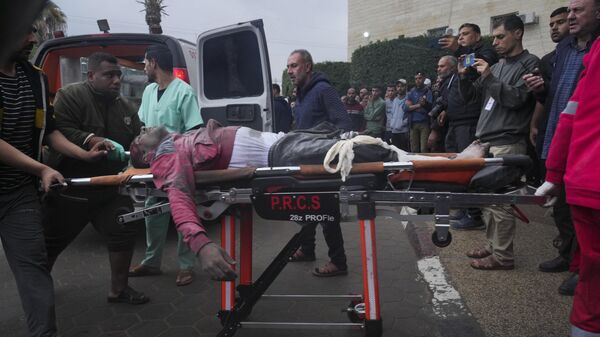 Транспортировка раненых в результате израильского удара в городе Дейр-эль-Балах 