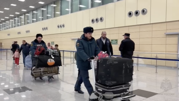 Сотрудники МЧС с эвакуированными из сектора Газа гражданами РФ в аэропорту Домодедово. 7 декабря 2023