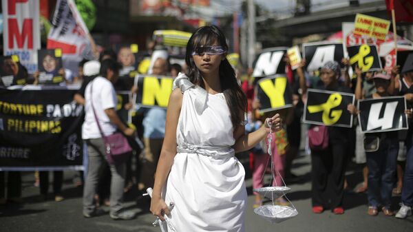 Филиппинская активистка во время акции протеста в Международный день прав человека у президентского дворца Малаканьянг в Маниле