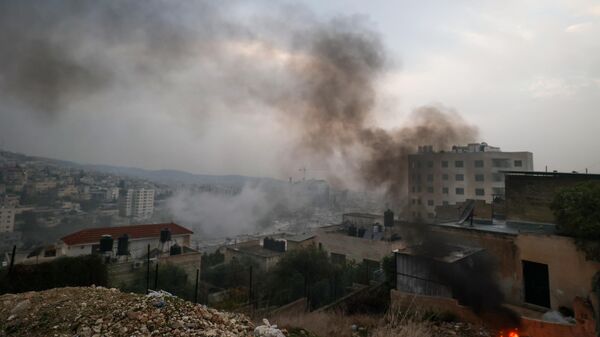 Дым в городе Дженин на Западном берегу реки Иордан