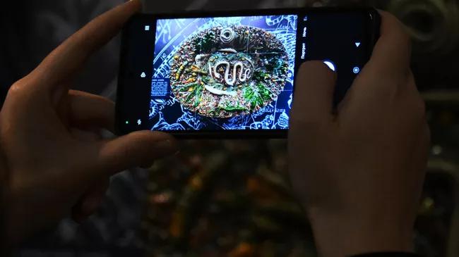 Посетительница фотографирует экспонат на выставке Под знаком зодиака в Историческом музее в Москве. На выставке представлены уникальные памятники, демонстрирующие знаки зодиака и их трактовку