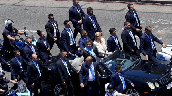 Президент Аргентины Хавьер Милей приветствует жителей Буэнос-Ареса из автомобиля