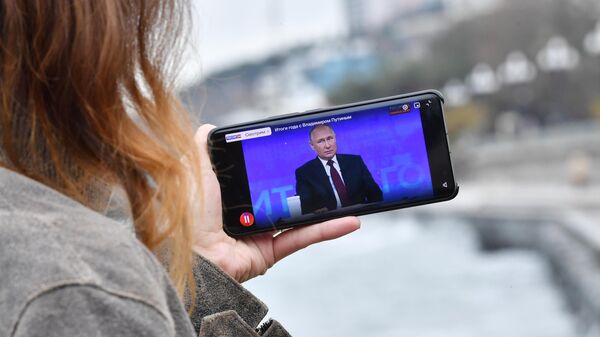 Жительница Симферополя смотрит трансляцию Прямой линии и большой пресс-конференции президента РФ Владимира Путина