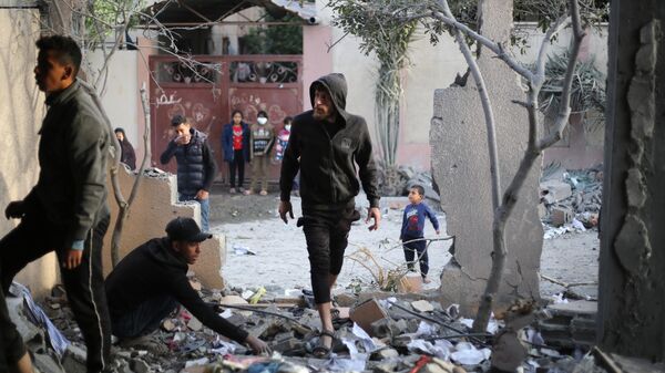 Жители города Хан-Юнис осматривают повреждения дома после израильской бомбардировки