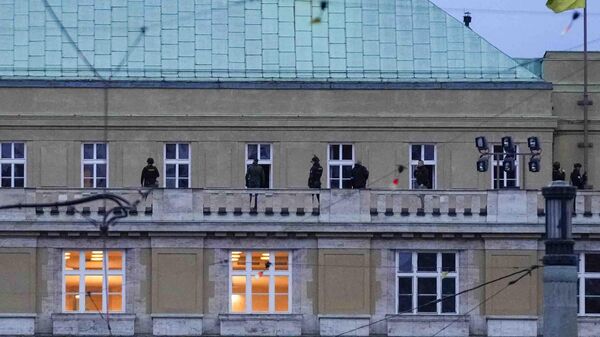 Полицейские стоят на балконе философского факультета Карлова университета в центре Праги, Чехия