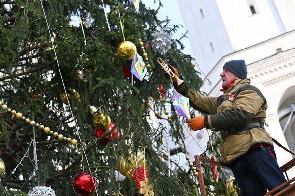 Рабочий украшает главную новогоднюю ель страны на Соборной площади Кремля в Москве