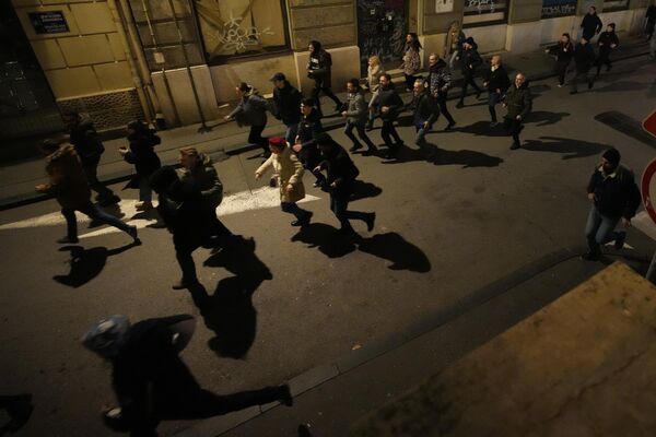 Протестующие убегают от полиции в Белграде
