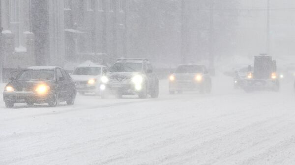 Автомобили на одной из улиц во время снегопада