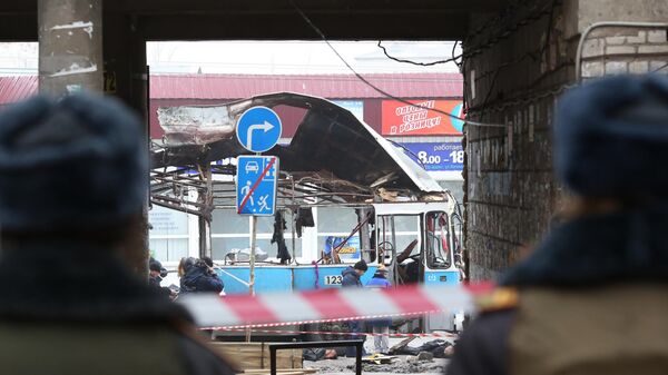 Сотрудники оперативных служб и правоохранительных органов работают на месте взрыва в троллейбусе рядом с Качинским рынком в Волгограде