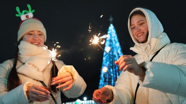 Девушки с бенгальскими огнями во время встречи Нового года в центре города Петропавловска-Камчатского