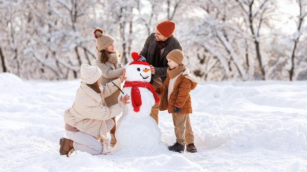 Семья лепит снеговика 